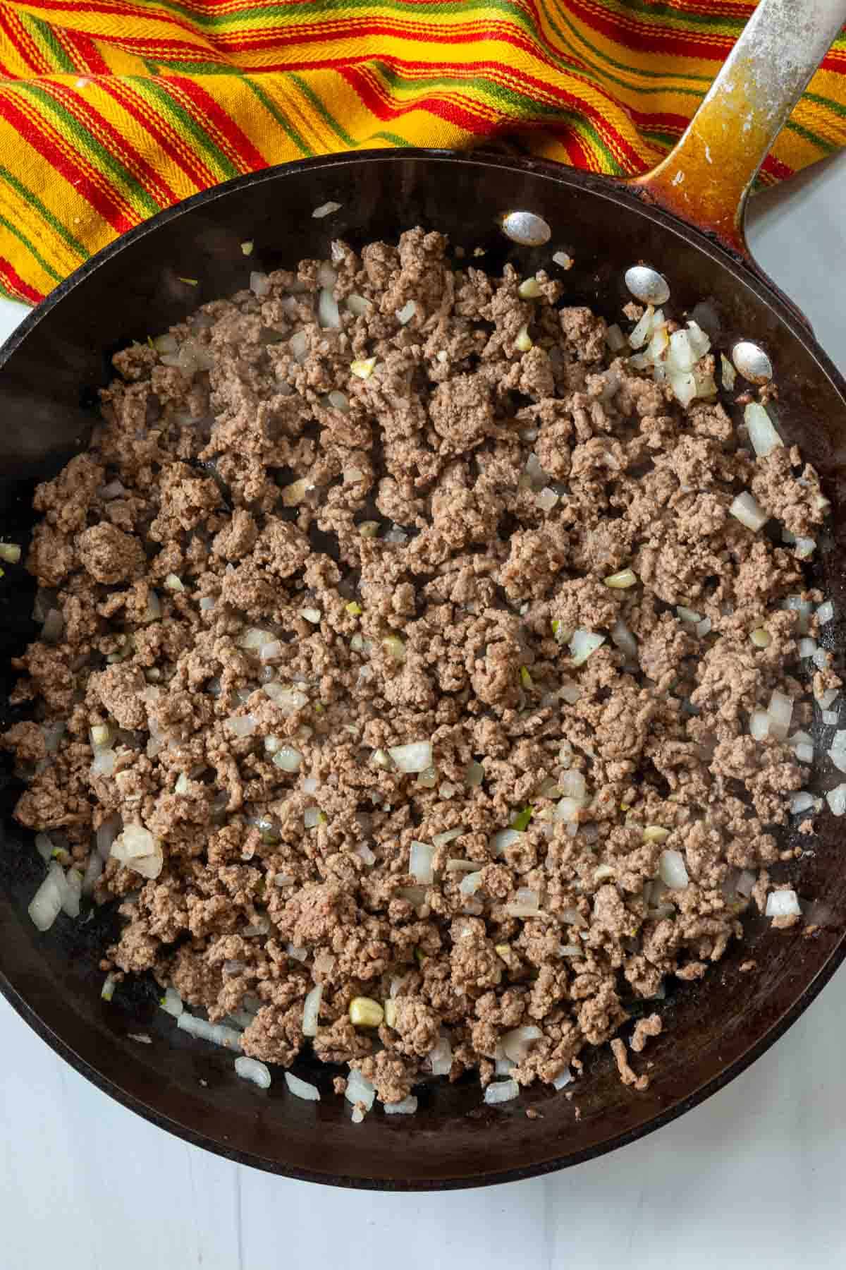 Cooking ground beef to make filling for enchilada burritos.