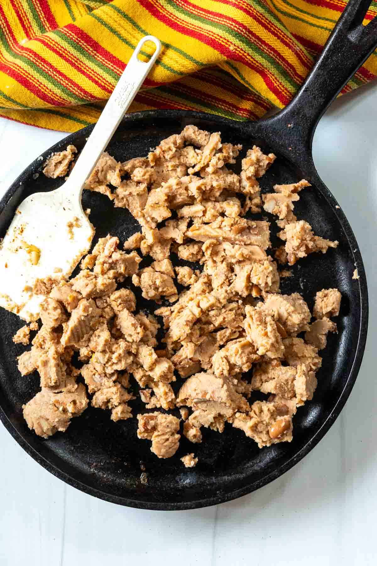 Warming refried beans to make enchilada burritos.