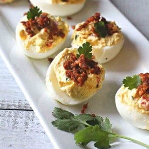 Mexican deviled eggs with chorizo served on a white platter.