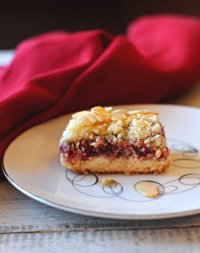 Raspberry bars made with almonds and raspberry jelly on antique tempo dessert plate