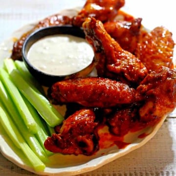 crispy baked wings with celery sticks and ranch dressing.