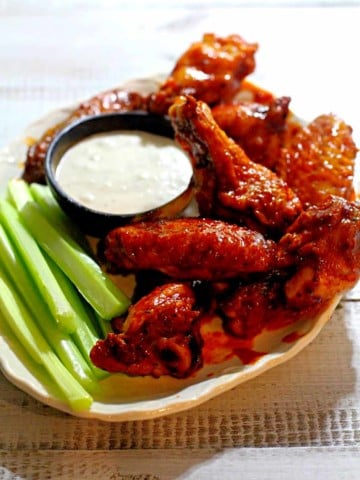 crispy baked wings with celery sticks and ranch dressing.
