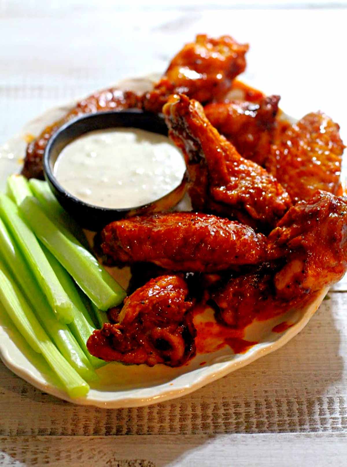 crispy baked wings with celery sticks and ranch dressing.