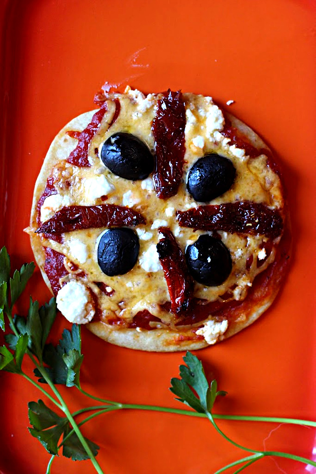 Tortilla pizza appetizer recipes. Flour tortilla topped with cheese, sun dried tomatoes, and olives.