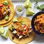 Roasted bell pepper tacos with black beans and chicken served on a white le creuset platter