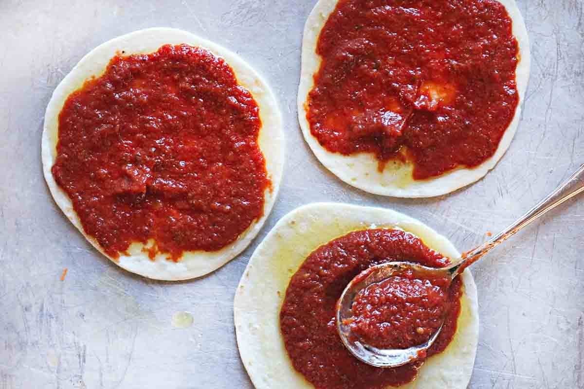 Step 2: adding sauce to flour tortillas to make flour tortillas pizza.