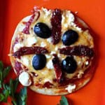 A flour tortilla pizza on a red plate.