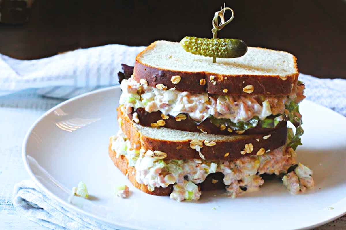 Ham salad sandwich topped with a cornichon.