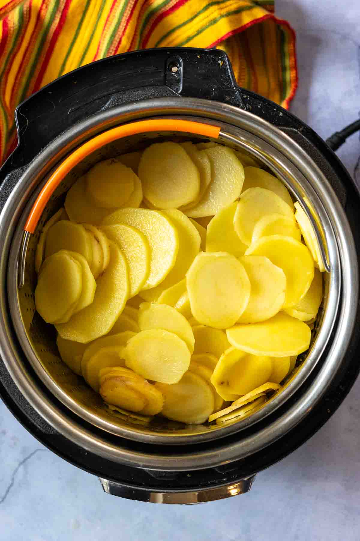 Cooking sliced potatoes in the Instant pot to make instant pot scalloped pottoes.