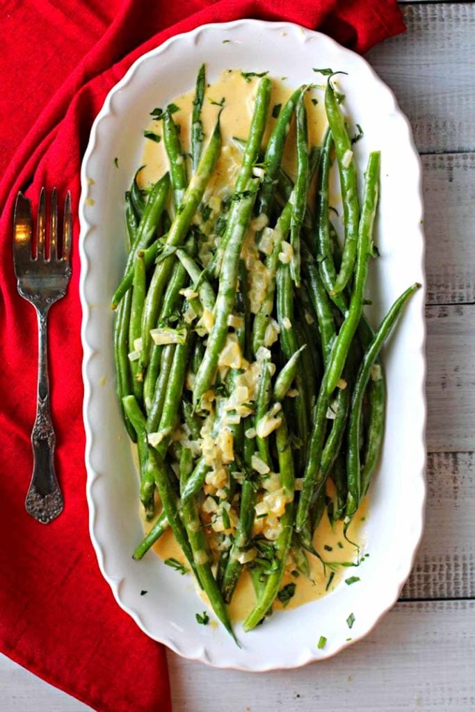 Green beans with grainy mustard sauce served on a white platter