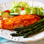 Farm raised salmon fillets baked with a peach jam glaze with a side of sauteed asparagus and a tossed salad