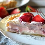 A slice of strawberry cream cheese tart topped with fresh sliced strawberries
