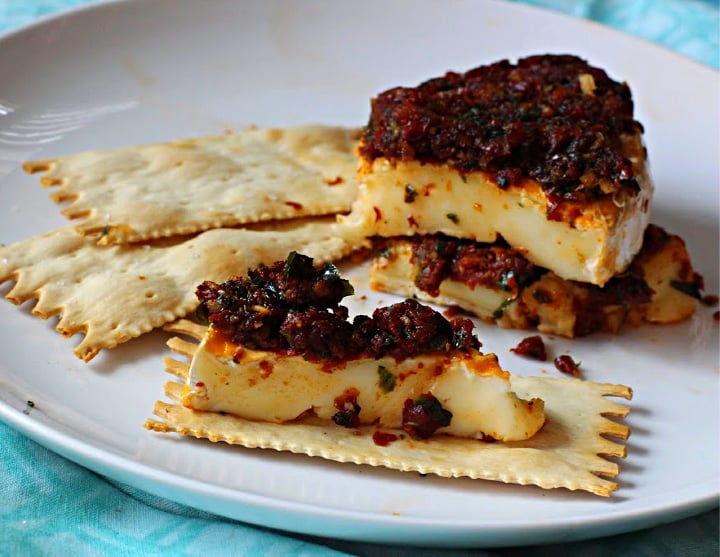 Stuffed sundried tomato brie on an artisan cracker