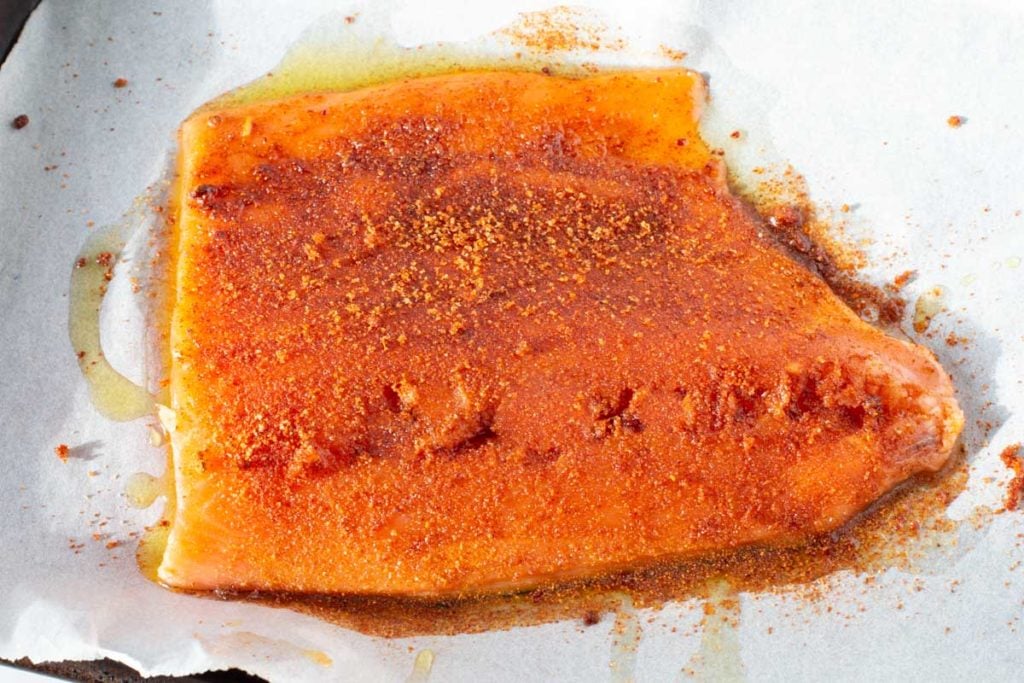 Adding a brown sugar chile powder rub to salmon fillet