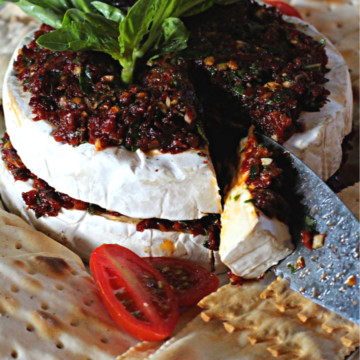 Two halves of a wheel of brie cheese to make stuffed brie appetizer.