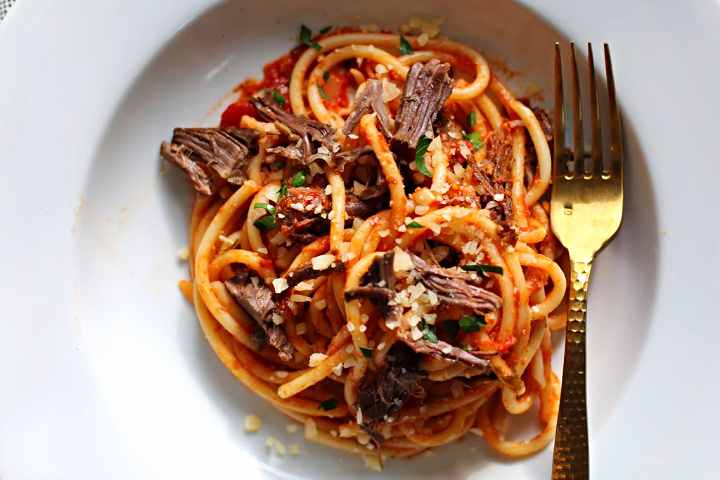 bucatini pasta with beef short ribs and capers. Topped with crumbled parmesan cheese.