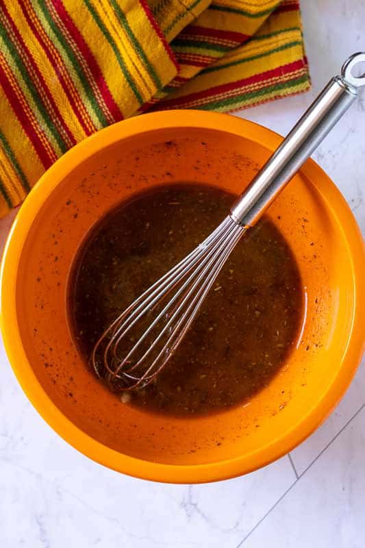 Whisking ingredients in a bowl for overnight flank steak marinade.