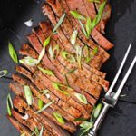 Grilled flank steak topped with sliced green onions