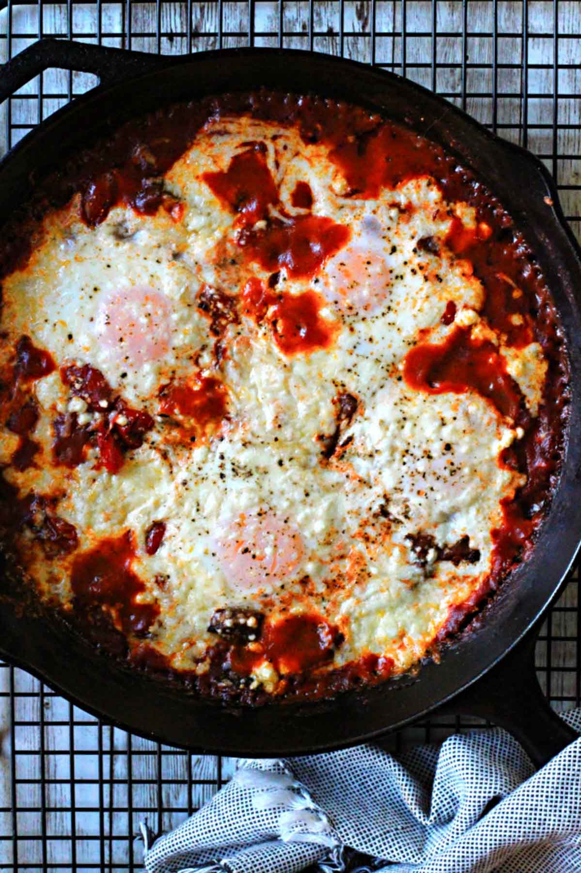 Baked Eggs for breakfast in a cast iron skillet with a spicy tomato sauce.