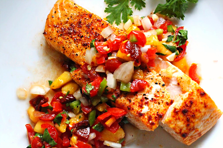 Spicy peach salsa served over a salmon fillet that's been seasoned with salt pepper and smoked paprika