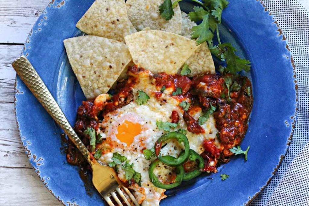 Mexican baked eggs served with tortilla chips and jalapeno peppers