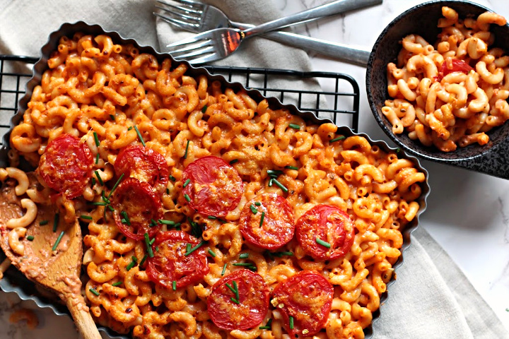 Mexican macaroni and cheese with sliced tomatoes on top. Served in a tart pan on a sheet pan grate.