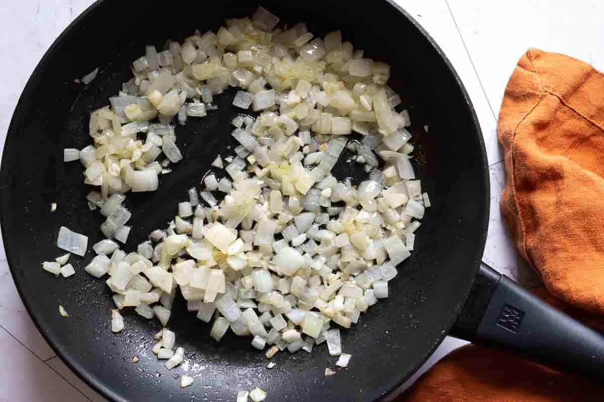 Step 1 to make Mexican Mac and cheese, cooking onions and garlic.