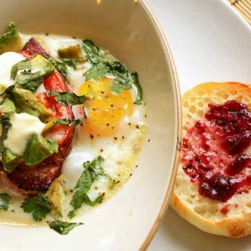 Baked Eggs with Ham and Avocado served with an English muffin.