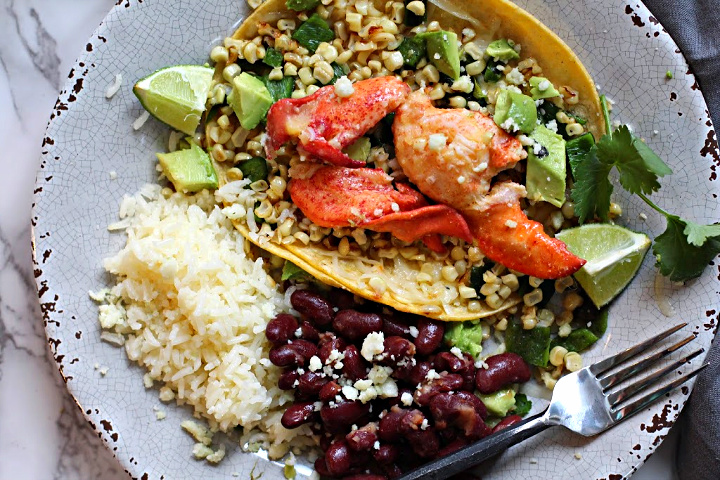 Lobster tacos on corn tortillas with melted muenster cheese, toasted sweet corn, roasted poblano peppers, avocado and lime wedges. Served with rice and beans.