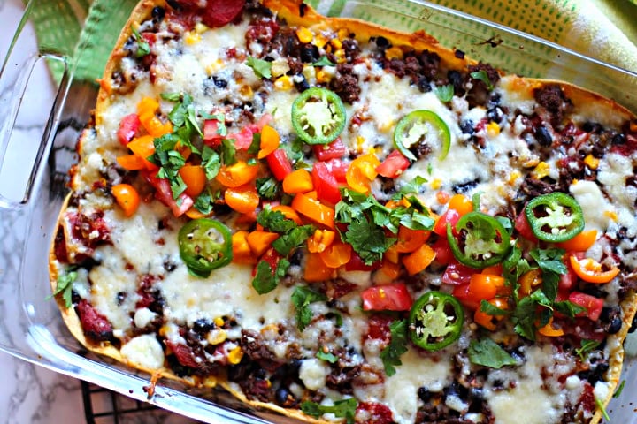 Mexican casserole made with ground beef, corn tortillas, sour cream, pepper jack cheese, sweet corn, black beans and canned tomatoes. Topped with fresh tomatoes, cilantro and jalapeno.