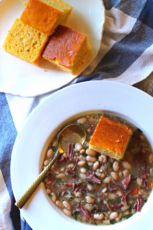 Ham and bean soup served with a slice of cornbread.