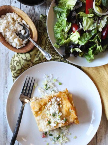 A slice of green chile chicken lasagna with a green salad.