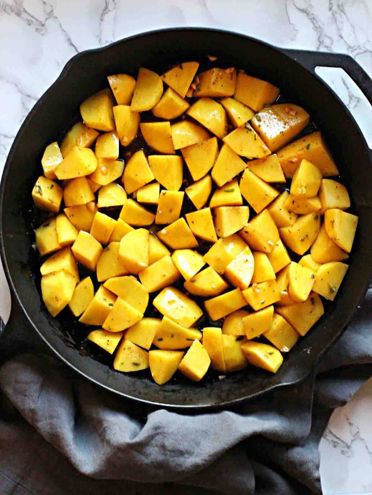 Cast iron skillet potatoes cooking.