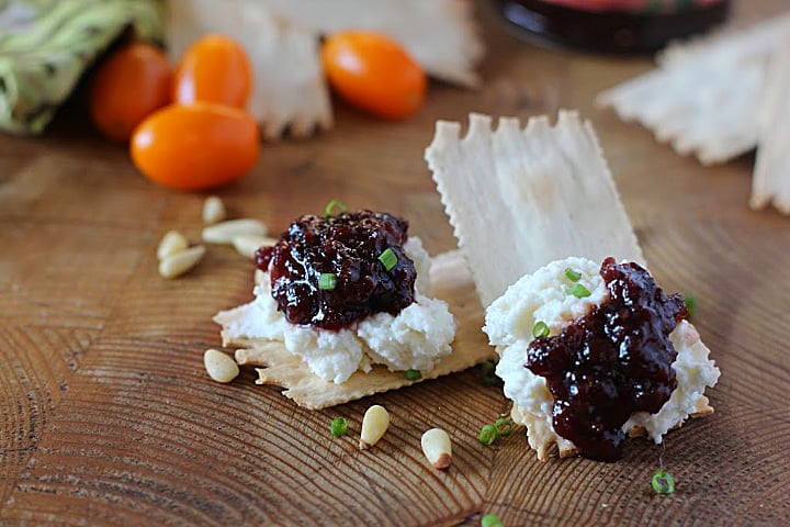 Wafer crackers topped with whipped goat cheese and Heidi's red chile raspberry jam. Placed on a wood cutting board