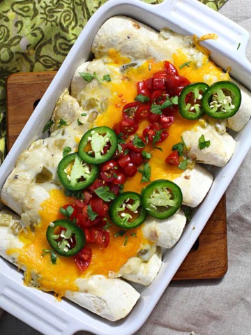 Breakfast burritos in a casserole dish filled with avocados and scrambled eggs.