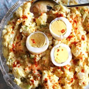 Old fashioned potato salad with olives, topped with sliced hard boiled eggs.