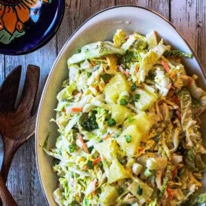 A dish of pineapple coleslaw with jalapeno peppers.