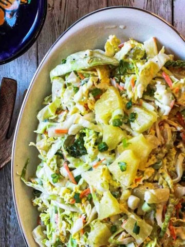 A dish of pineapple coleslaw with jalapeno peppers.