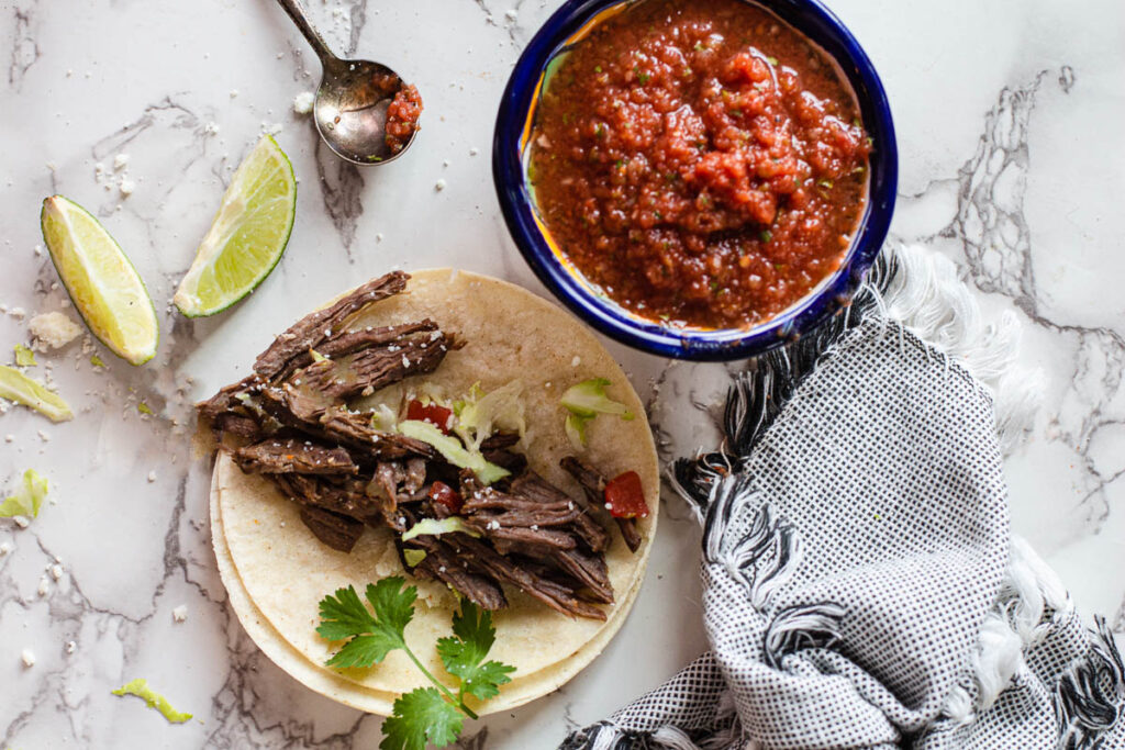 Crockpot roast beef tacos with cabbage limes and salsa