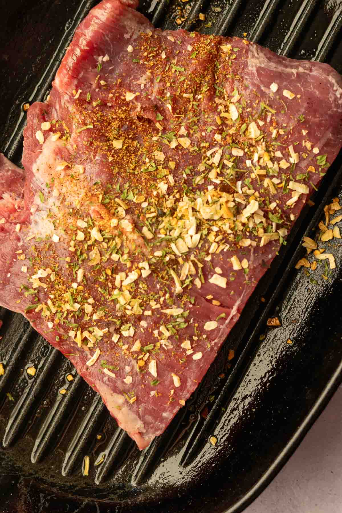 Seasoning steak to make skirt steak salad.