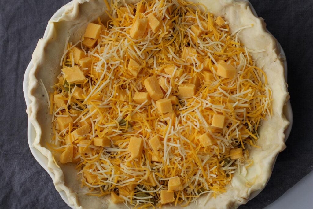 Cubed cheddar cheese and shredded cheese to make a quiche