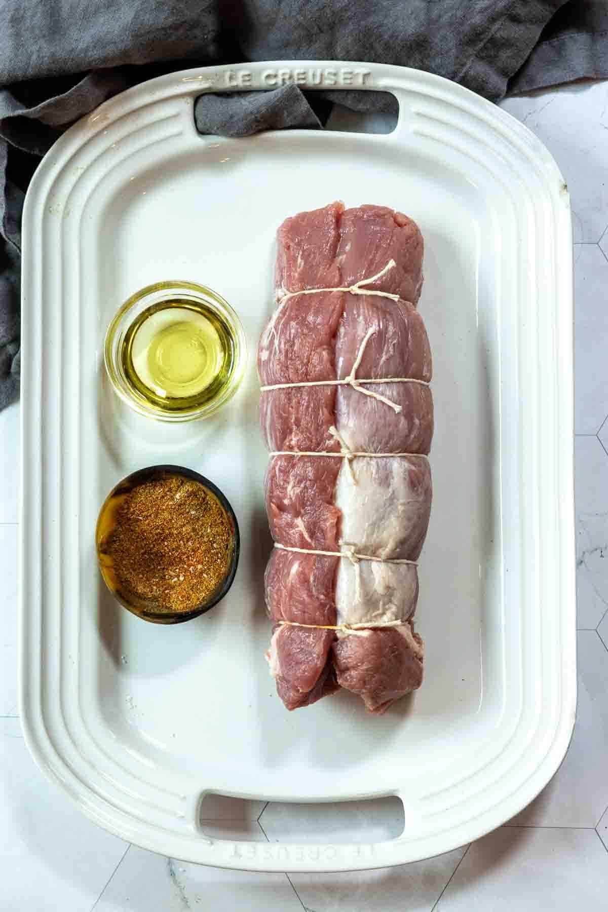 Tying together two tenderloins to make baked pork tenderloin.