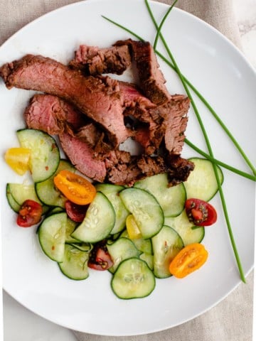 Asian marinade for grilled flank steak served with asian cucumbers and garnished with chives