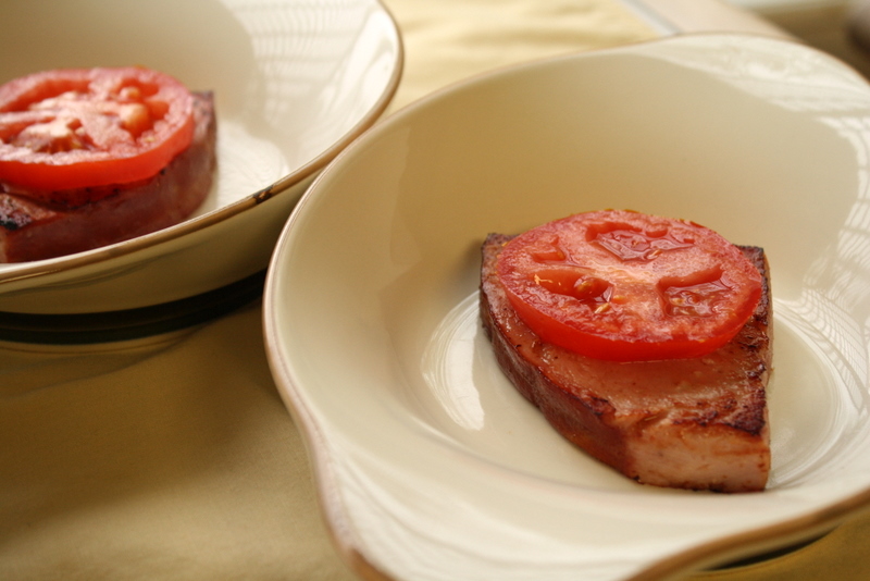 A slice of toast topped with a slice of fresh garden tomato.