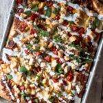 BBQ chicken pizza cooked in a sheet pan with tomatoes, jalapeno, cilantro and drizzled with ranch dressing