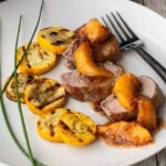Pork tenderloin topped with a peach whiskey sauce served with sliced and grilled summer squash