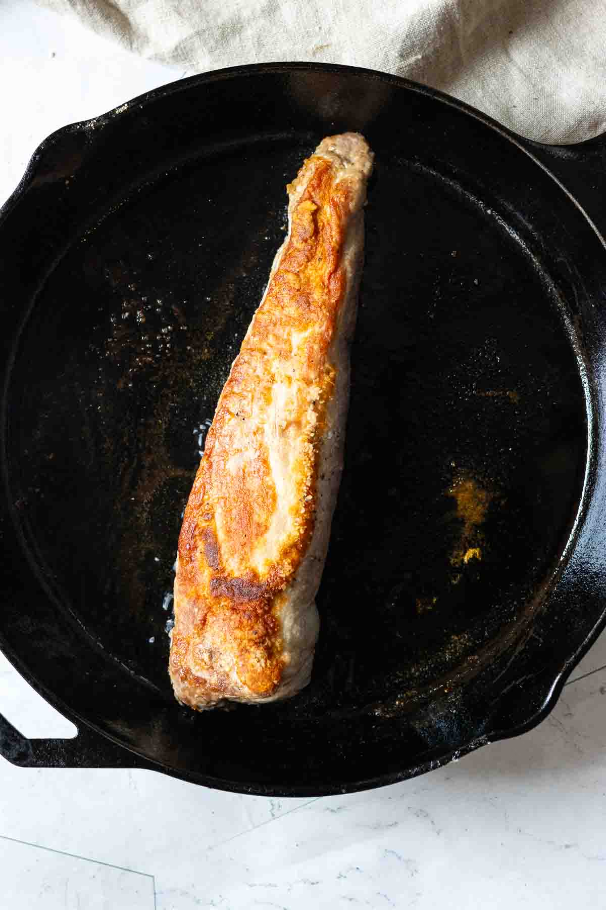 Frying a whole pork tenderloin in a cast iron skillet.