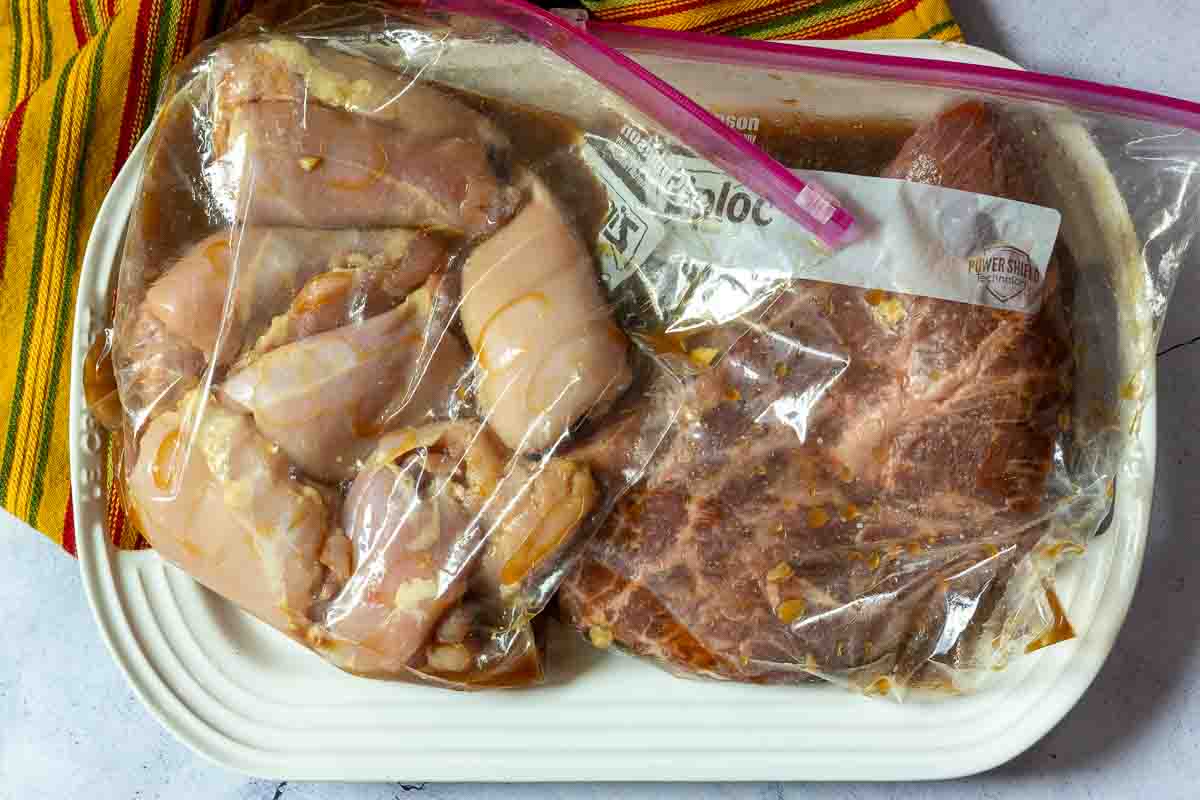 Packages of chicken and steak marinating in flank steak fajitas marinade.