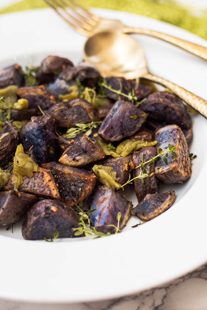 Purple roasted potatoes with garlic, thyme and green chile peppers