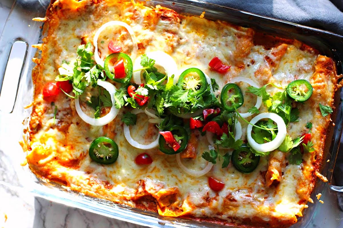 Creamy chicken enchiladas casserole baked in a pyrex baking dish.